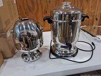 Both coffee urns side by side on table