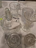 Group shot of assorted cut crystal and glass pieces showing decanter, vases, tumblers, dishes