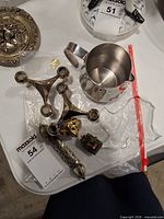 All items grouped: stainless pitcher, pair candlesticks, clear acrylic tray, three pieces costume jewelry