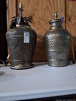 Front view of both ornate metal lamp bases on table