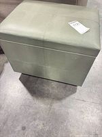 Top and front view of sage green crocodile-embossed storage ottoman