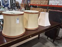 All three lampshades on table showing relative sizes and shapes