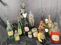 Group shot of all apothecary bottles, skeleton props, lantern and candle