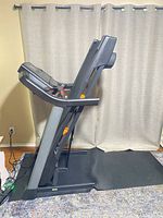 Treadmill folded upright on mat