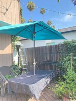 Table with umbrella and tablecloth on deck