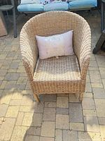 Front view of wicker rattan barrel chair with pillow