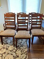 Front view of six ladder back chairs showing upholstery and wood finish