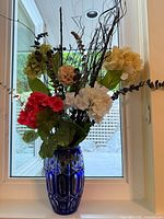 vase with silk floral arrangement in window