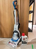 Hoover FH50700 VM7.0 carpet cleaner standing upright with solution bottle