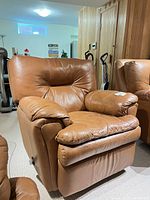 Full view of brown leather swivel rocker recliner in room setting