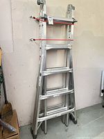 Folded Mastercraft aluminum articulating ladder leaning against wall