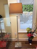 full view of chrome and acrylic floor lamp with fabric shade
