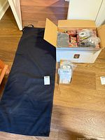 Box with decorative boxes, wire spools in bags, roll-up bag on floor