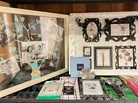 Entire lot on shelf: boxed Umbra frame, family tree frame, Royal Selangor plate box, plate hangers, magnifier, pouch