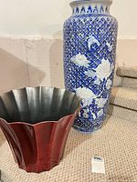 Overall view of porcelain vase and red metal planter