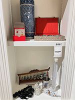 Overall lot on shelving showing vase, cups box, bells, hydrometer and accessories