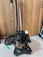Rainbow SE vacuum on wheeled base with hose, wand and floor nozzle visible