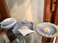 Group shot of plate, lidded box and hexagonal tray inside cabinet