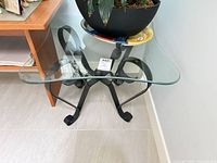 Full view of side table showing glass top and wrought iron base