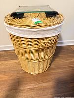 Full view of wicker hamper with liner and scale resting on lid