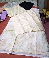 Mixed pillow shams and covers laid on bed showing variety of colours and patterns