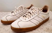 Left side view of Adidas Gazelle sneakers showing gold branding and gum soles
