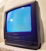 Front three-quarter view of Panasonic CRT TV/VCR combo powered on displaying blue screen