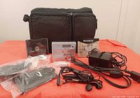 All items overview on red cloth: player, discs, adapters, headphones, carry bag