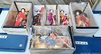 All six boxed dolls with lids removed showing water marks on outer boxes