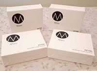 Four sealed Mies BT100 boxes front angles
