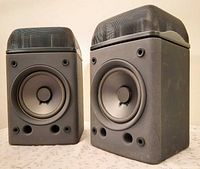 Front angled view of both speakers showing drivers, ports and tweeter housings