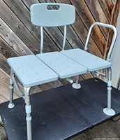 Front view of light grey transfer bench showing seat, backrest, frame and adjustable legs