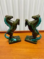Both horse bookends front view on wooden surface