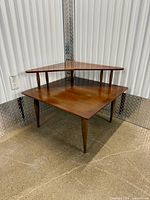 Two-tier corner table front view showing shape and legs