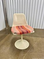 Front view of fiberglass tulip chair with striped cushion