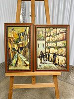 Both framed oil paintings on easel