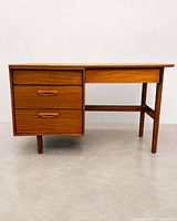 Full view of teak desk showing drawers, top, legs and stretcher