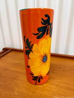 Full view of vase showing floral design and orange body