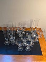 Sixteen assorted champagne glasses arranged on table