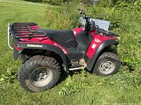 Left side view of Bombardier Traxter ATV showing overall condition, rear rack, tires and fenders