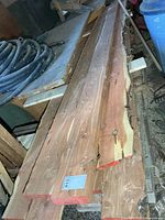 Stack of rough-cut red cedar boards on top of pile, showing thickness and live-edge