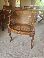 Front view of wood barrel chair with cane panels