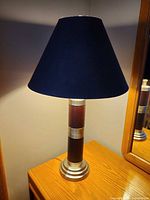 Full view of lamp on table showing shade and metal base