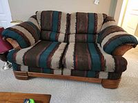 Front view of upholstered two-cushion loveseat with southwest pattern and wood trim