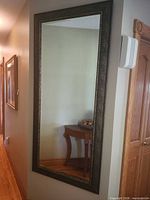 Full view of framed wall mirror mounted on hallway wall