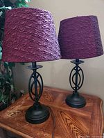 Pair of metal base table lamps on wood table