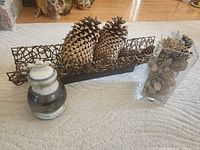 Group shot showing glass vase with pine cones, twig centerpiece with two sugar pine cones, and ceramic ginger jar
