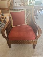 Front view showing wicker construction, bent bamboo arms, cushions