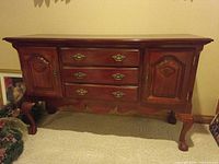 Front view of wood server sideboard showing drawers, doors, hardware