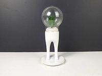 Front view of ceramic leg planter under glass globe with faux succulent